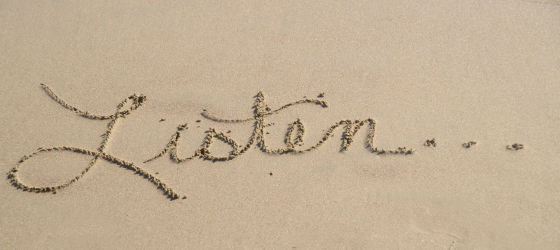 scritta su sabbia "listen"