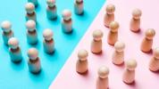 una schacchiera colorata di rosa e blu con pedine di legno disposte di fronte